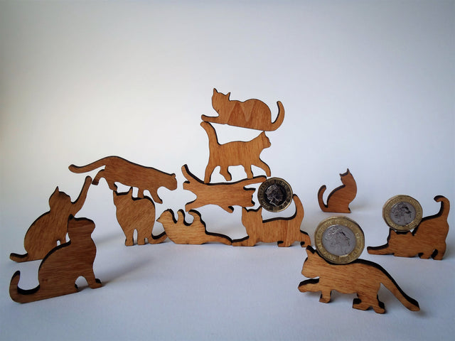 twelve wooden cat ornaments in a pile