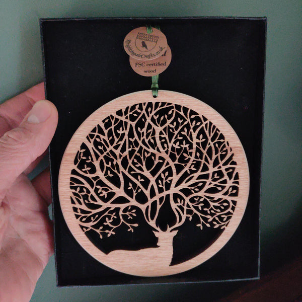 Wooden wall ornament in a box of a stag with antlers that create branches of a tree